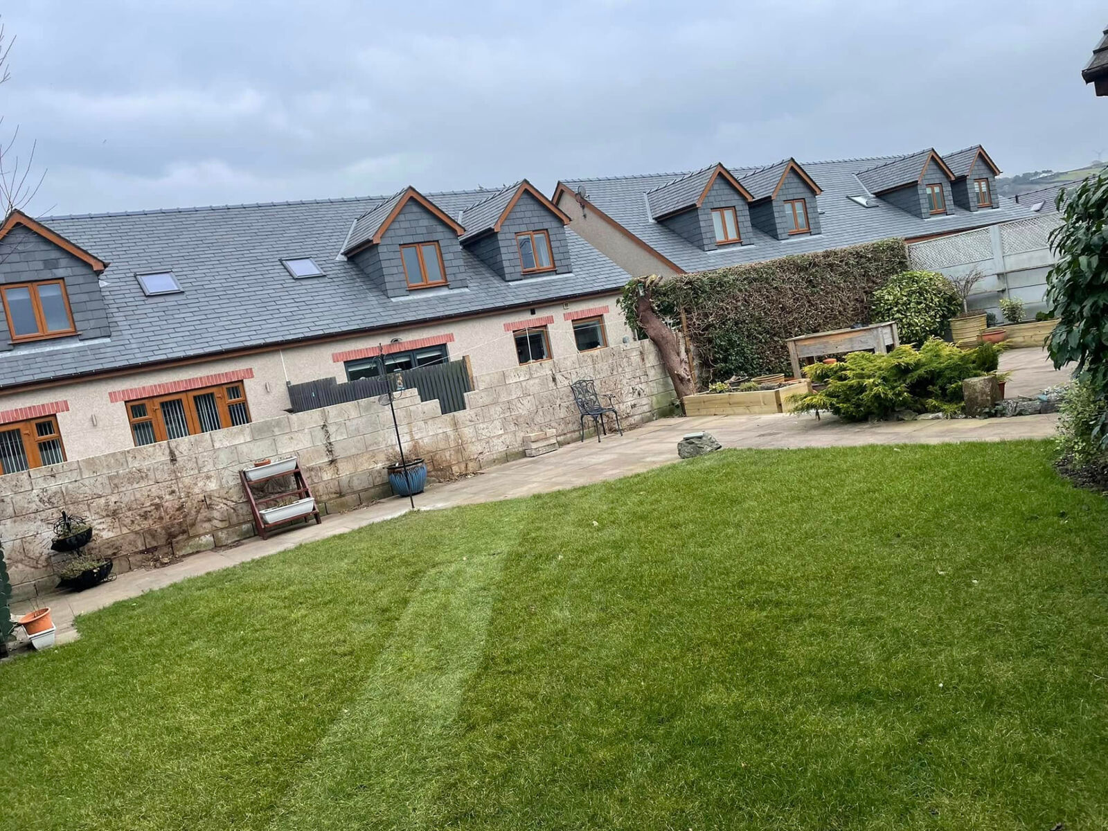Freshly mown striped rear lawn beside a paved patio