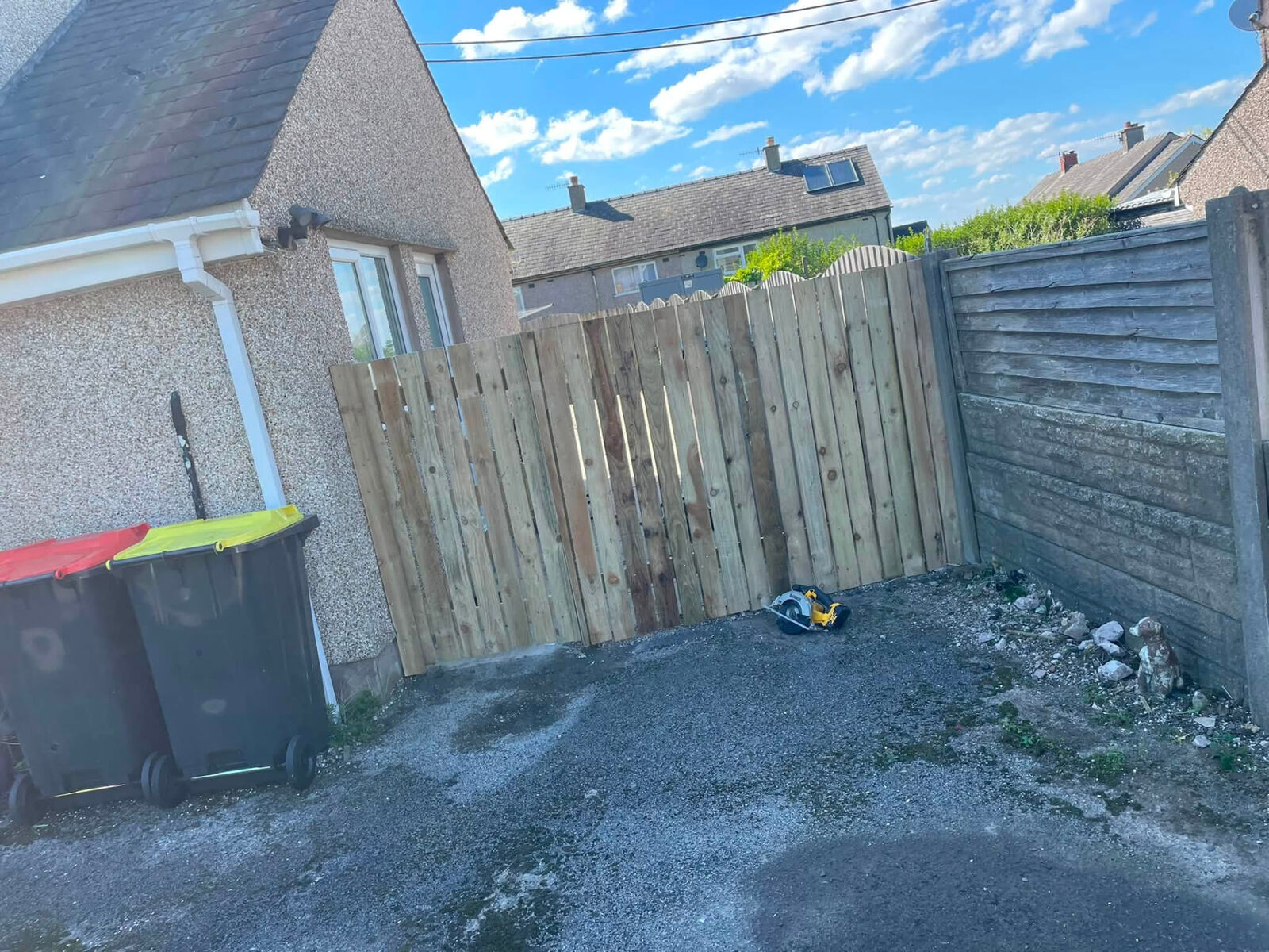 New vertical timber fence section in a rear yard next to an older panel fence
