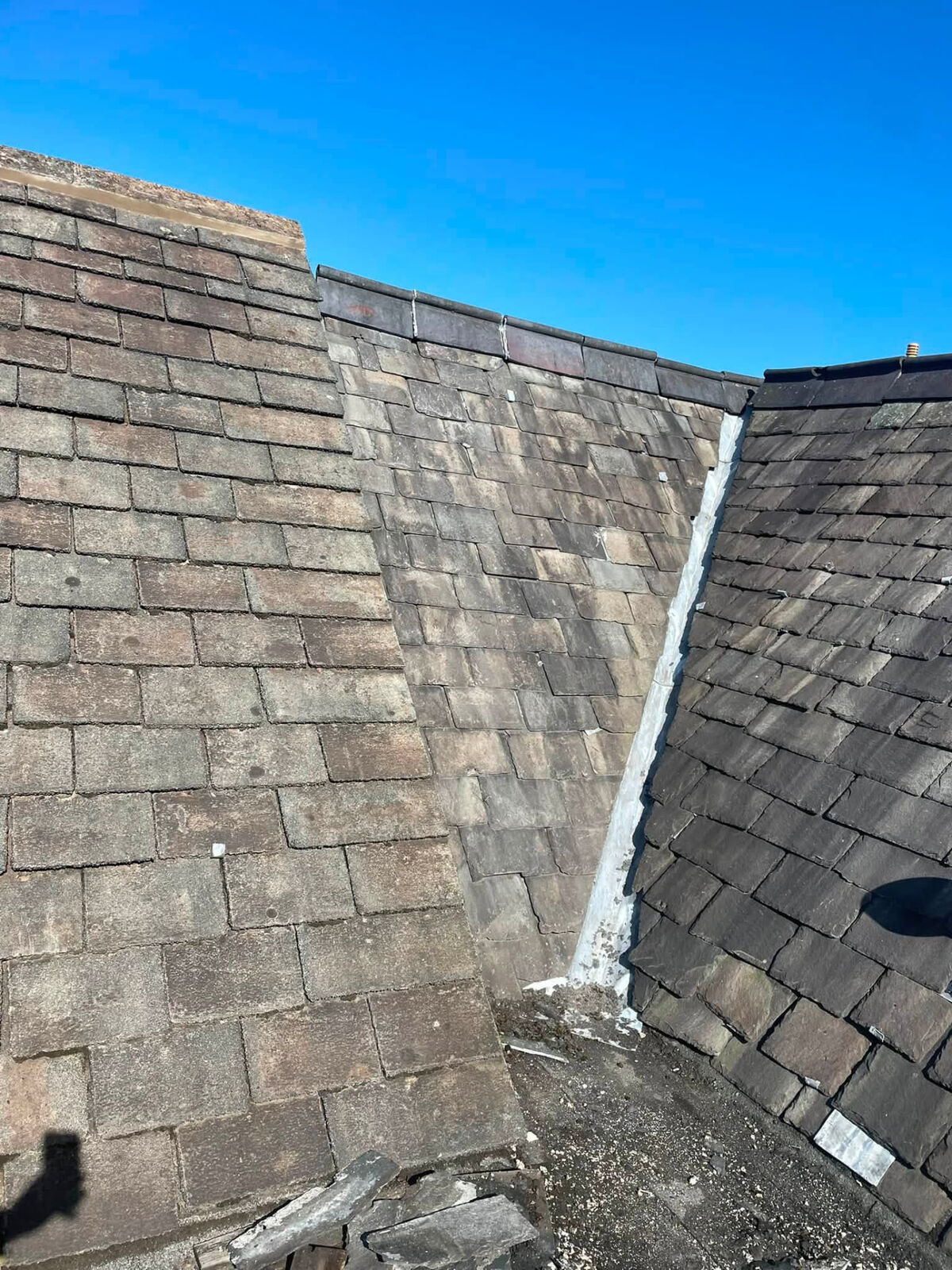 Slate roof slopes meeting at a valley during roof maintenance work